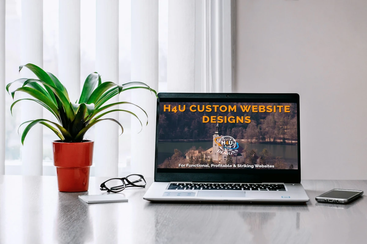 custom website design laptop and plant on a desk